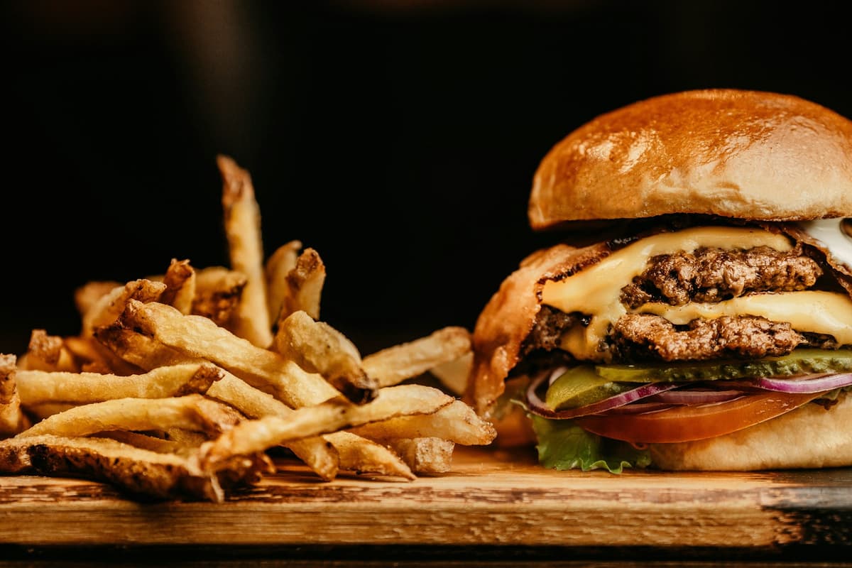 Cheeseburger with a side of fries on a wooden board